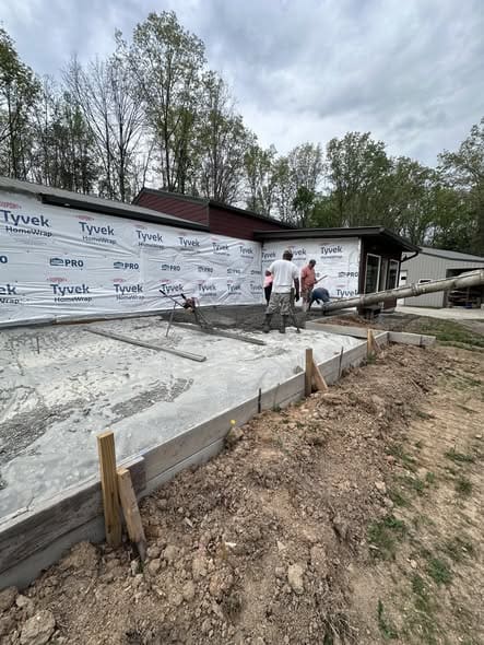 Freshly poured concrete slab in Lyles, TN for a 1,100-square-foot home addition before framing begins.